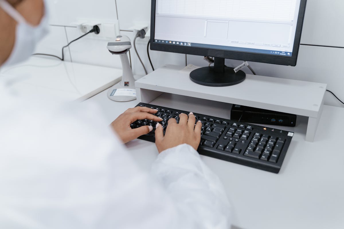 Lab researcher in a white coat placing an order at their workstation